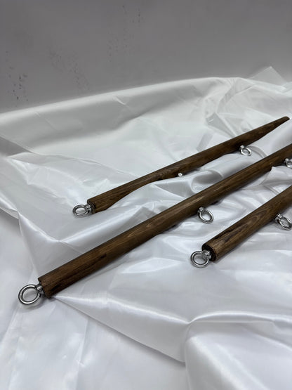 Solid wood spreader bar with metal attachment rings, available in fixed lengths (40, 60, 80 cm), designed for wrist or ankle restraint in BDSM play
