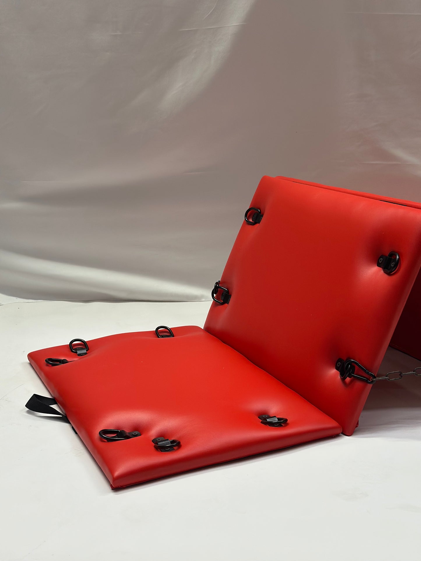 Foldable faux leather spanking bench in black with metal restraint hooks, portable BDSM furniture for bondage play.