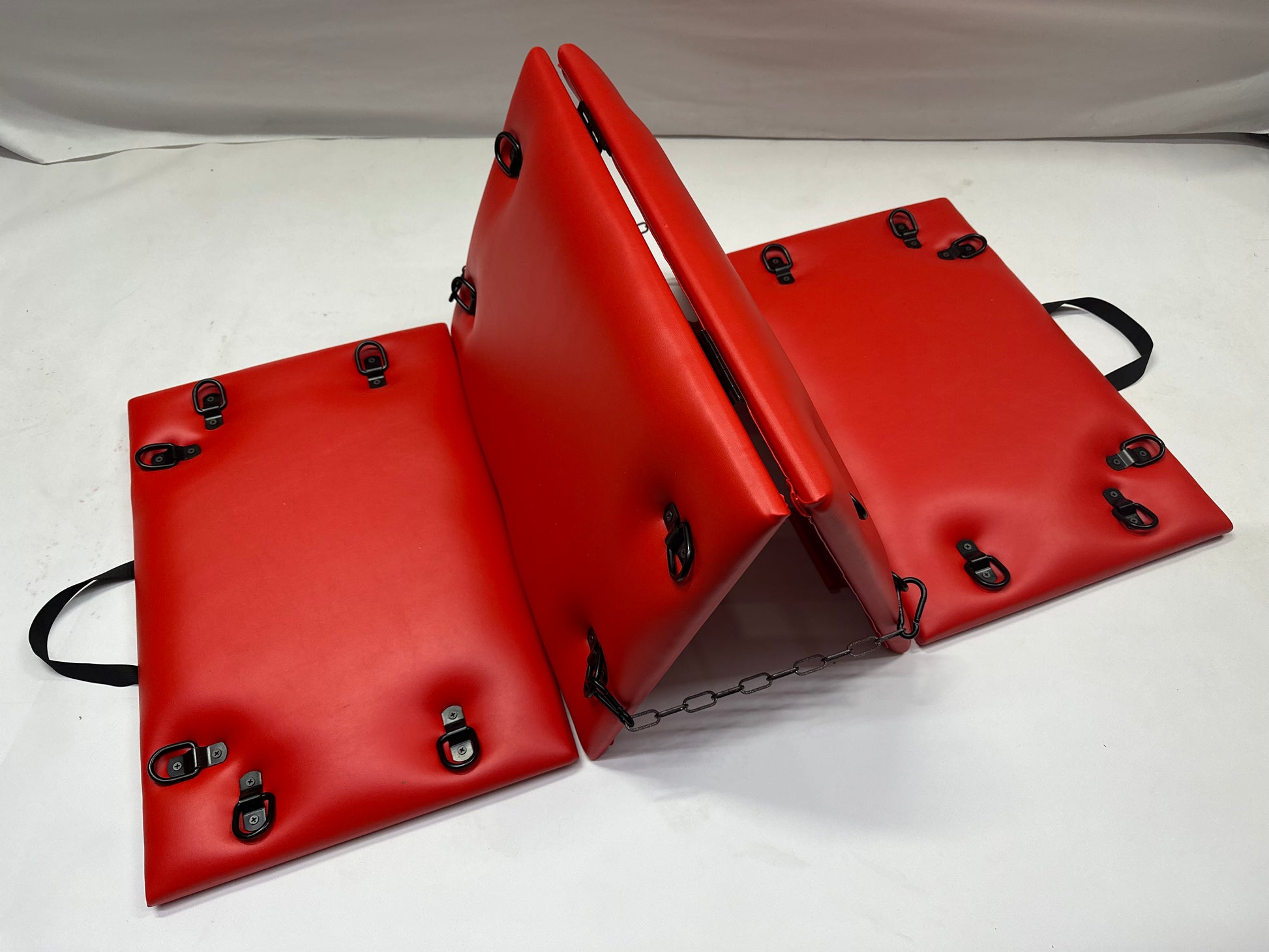 Foldable faux leather spanking bench in black with metal restraint hooks, portable BDSM furniture for bondage play.