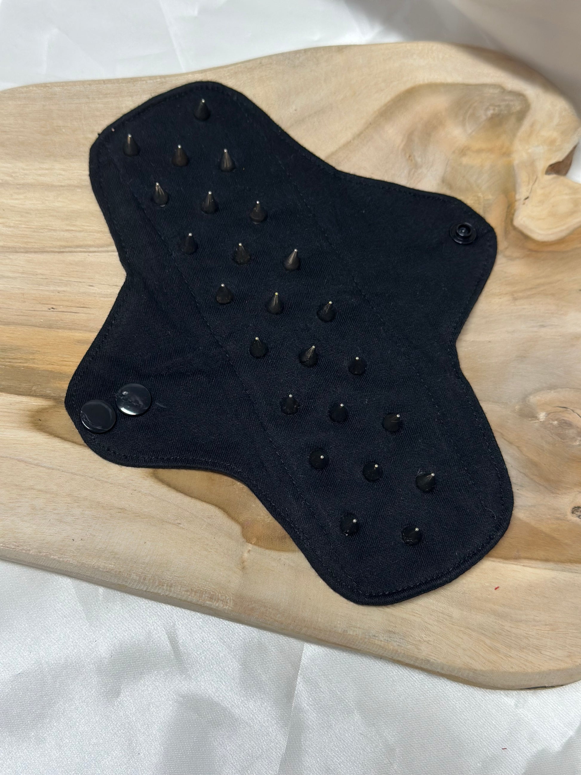 Spiked BDSM discipline pad made of fabric with stainless steel spikes for sensory play and pain exploration.