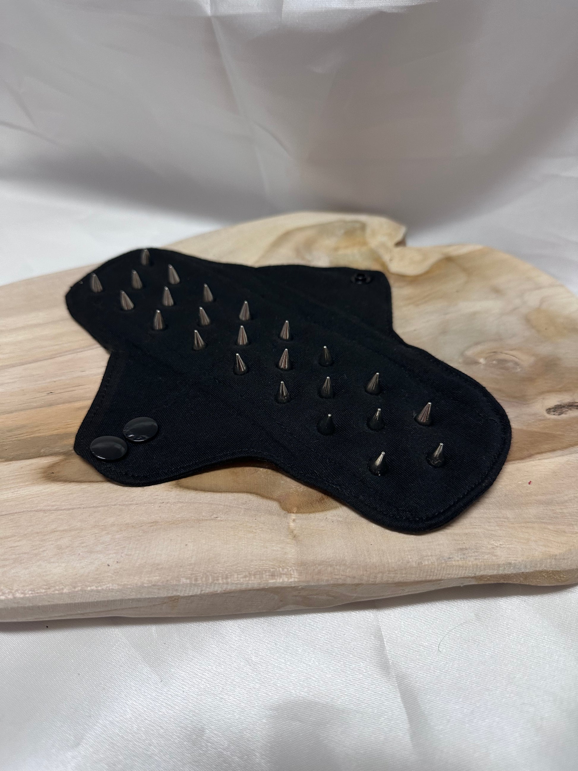 Spiked BDSM discipline pad made of fabric with stainless steel spikes for sensory play and pain exploration.