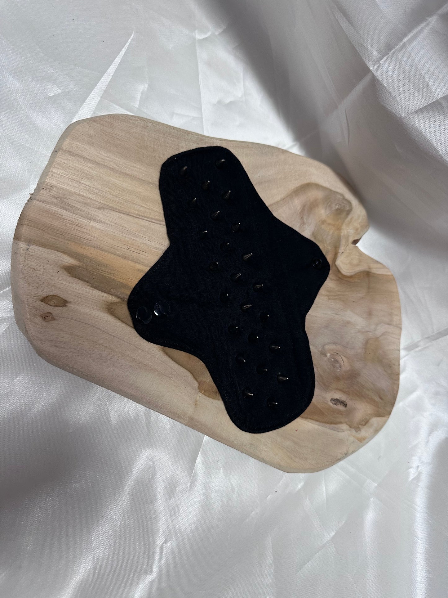 Spiked BDSM discipline pad made of fabric with stainless steel spikes for sensory play and pain exploration.