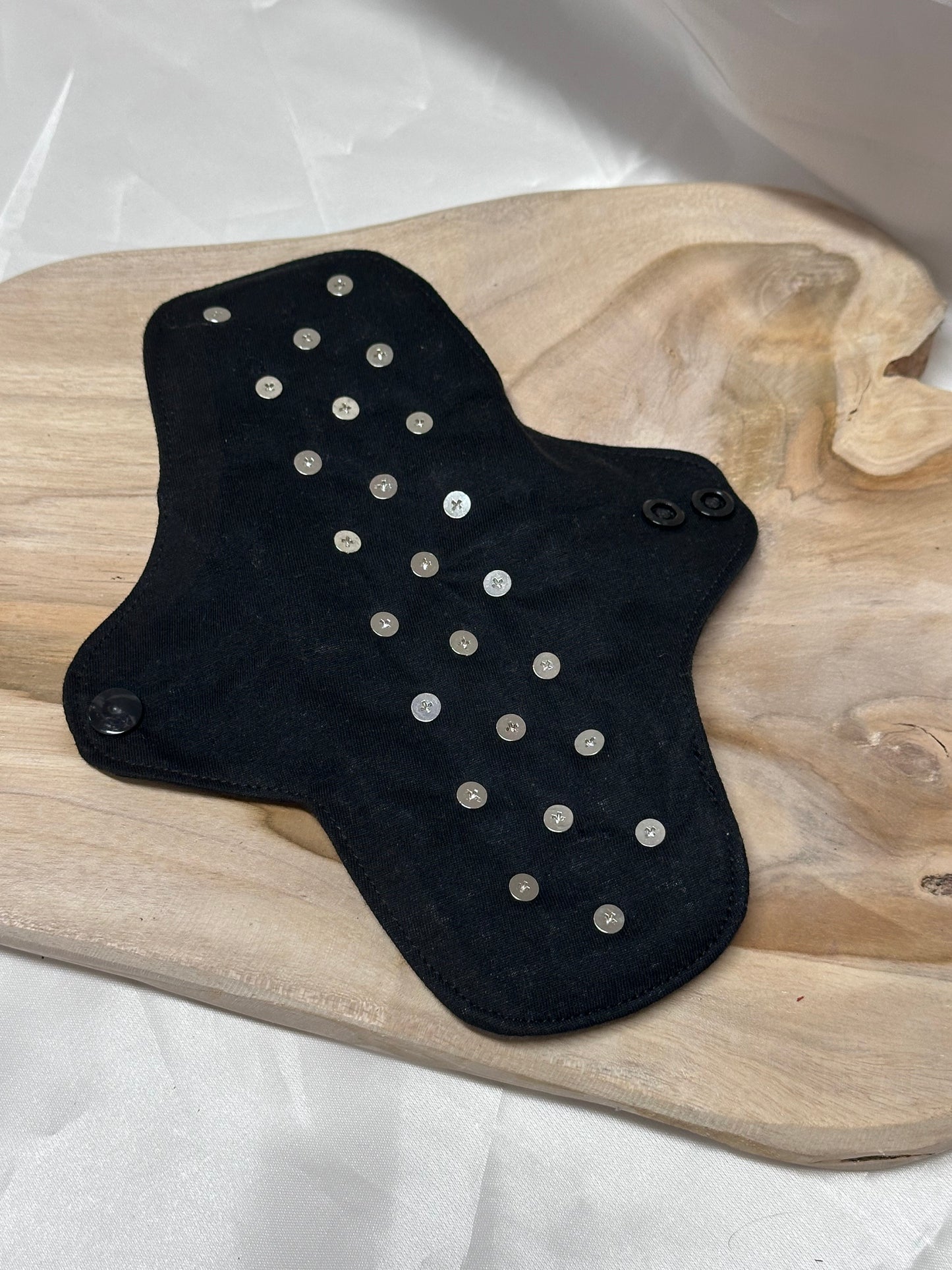 Spiked BDSM discipline pad made of fabric with stainless steel spikes for sensory play and pain exploration.