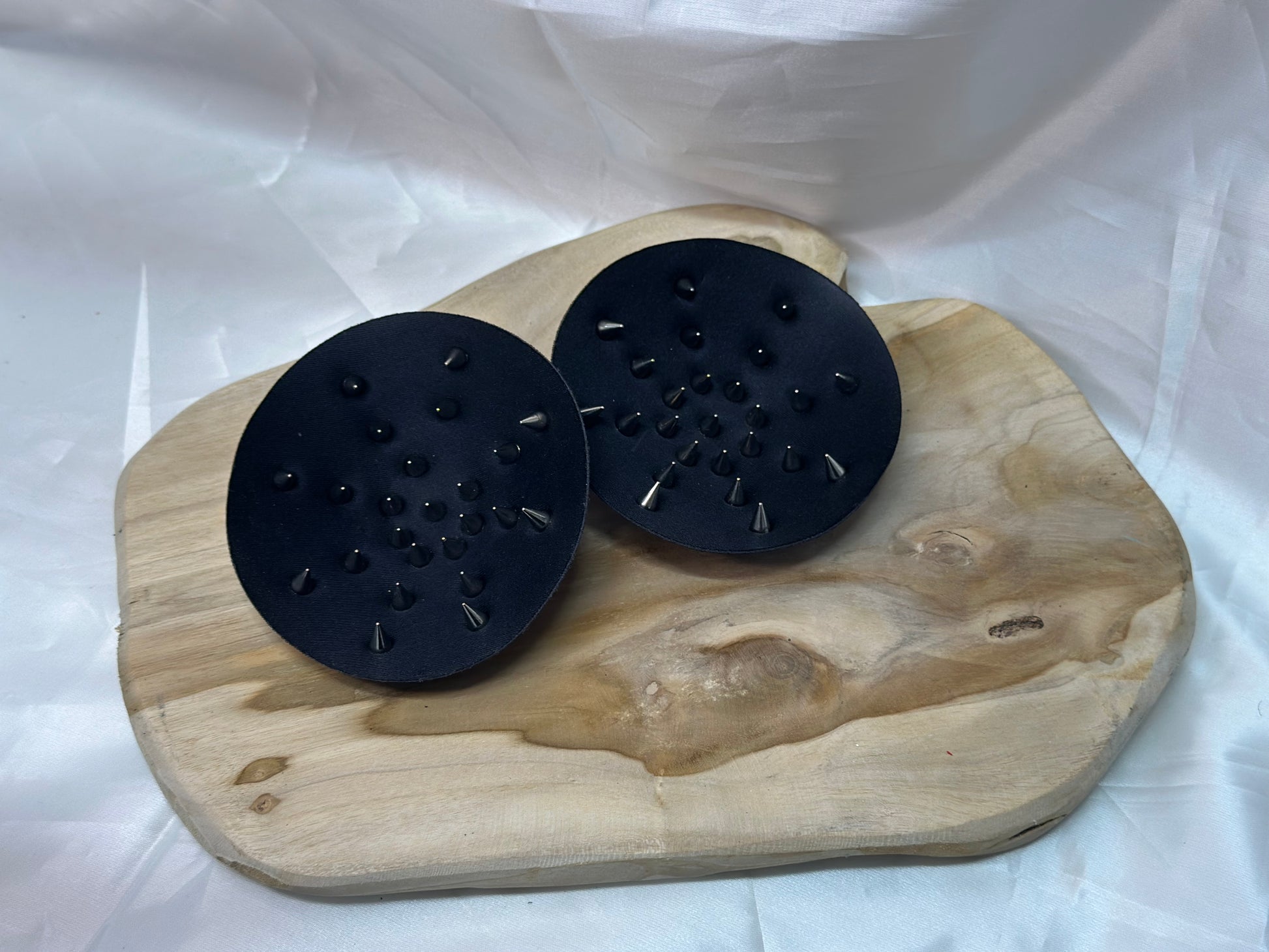 Pair of spiked bra inserts made from fabric with metal spikes for BDSM and sensory play.