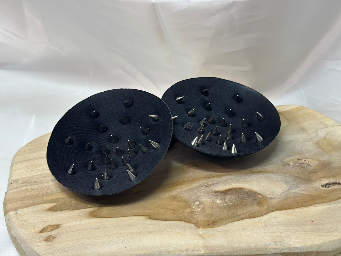 Pair of spiked bra inserts made from fabric with metal spikes for BDSM and sensory play.