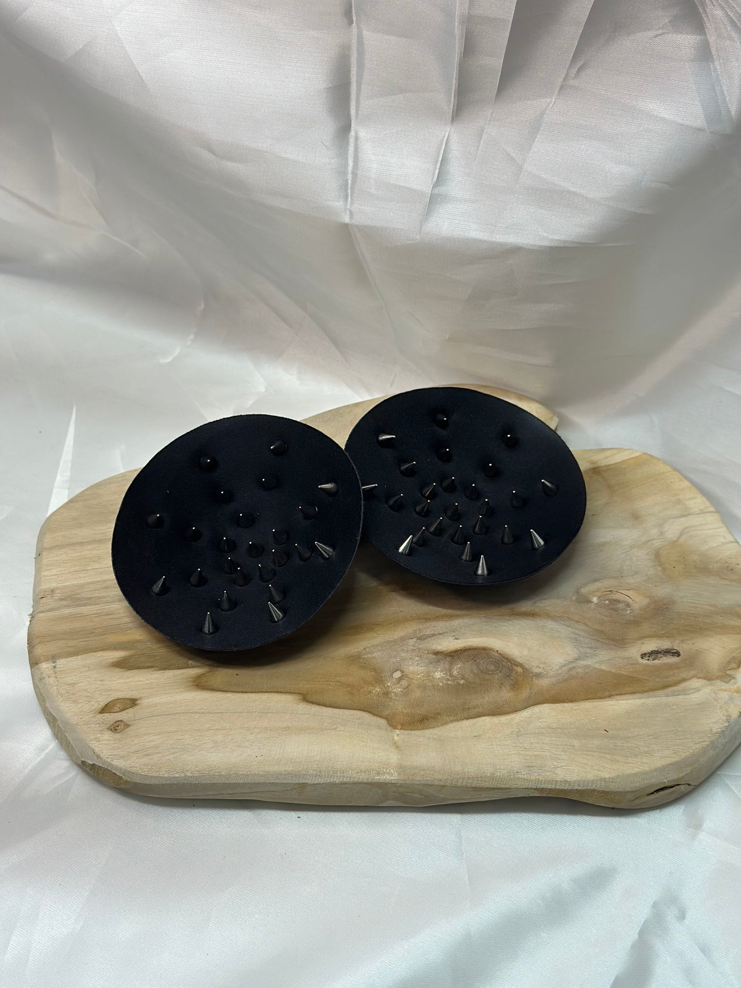 Pair of spiked bra inserts made from fabric with metal spikes for BDSM and sensory play.