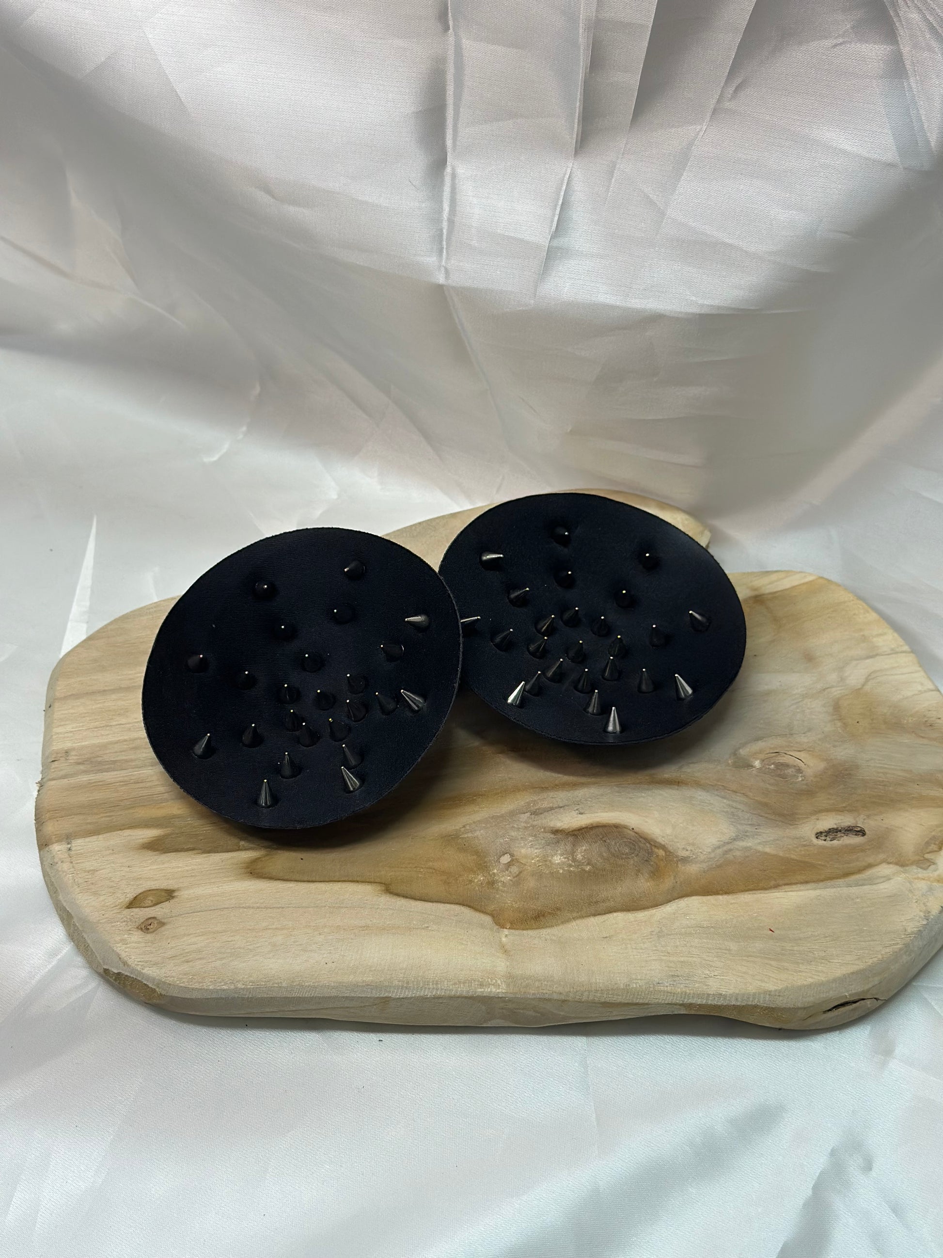 Pair of spiked bra inserts made from fabric with metal spikes for BDSM and sensory play.