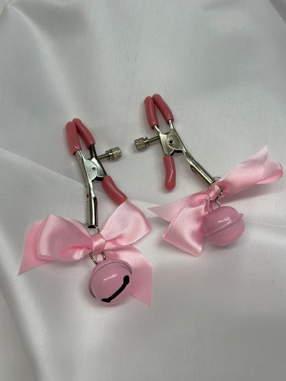 BDSM nipple clamps with decorative bows for playful kink