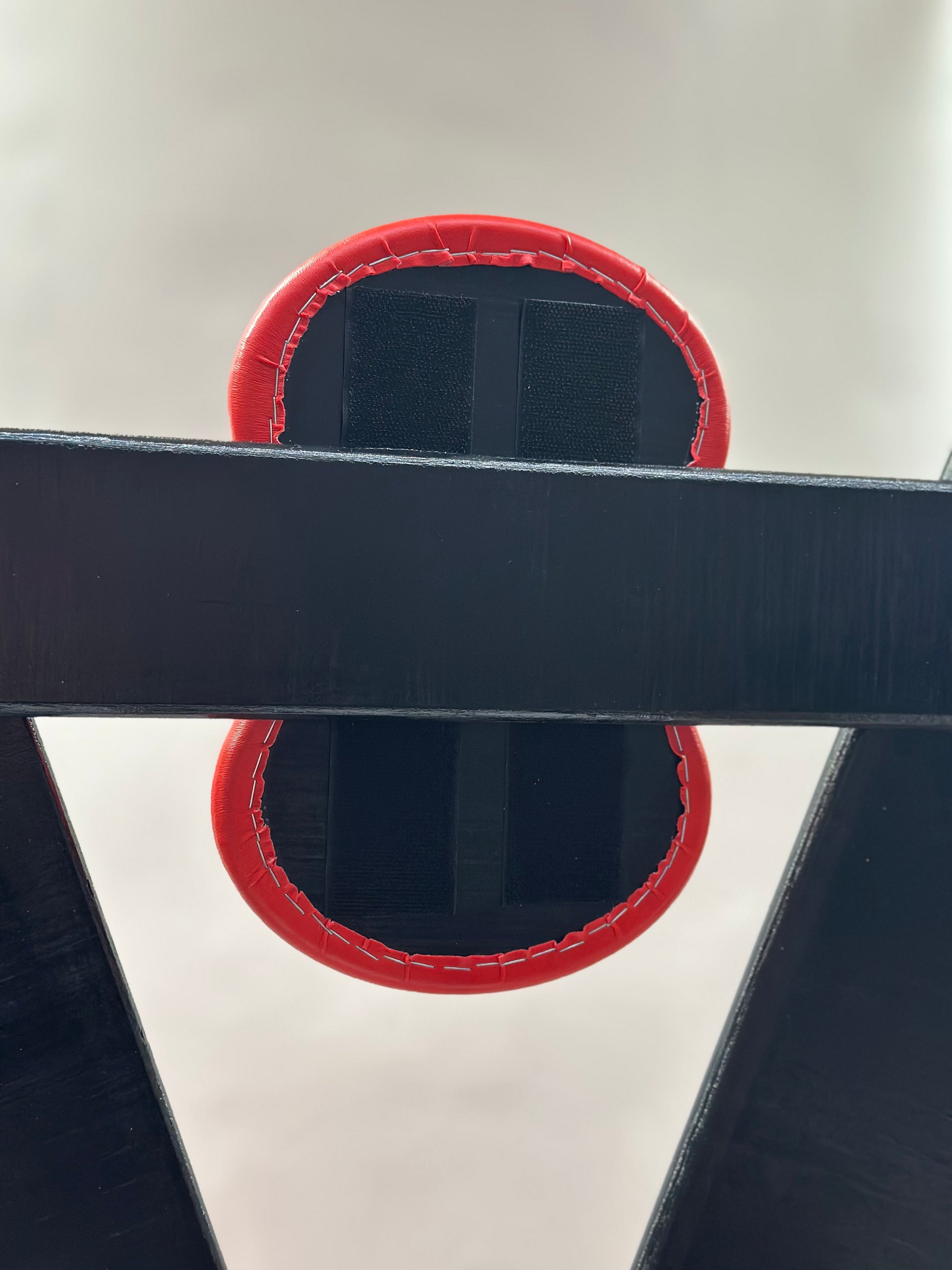 St. Andrew’s Cross made of hardwood with black padded cushions, adjustable restraints, and quick-release hinges for easy storage.