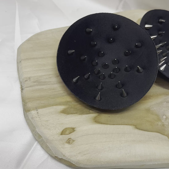 Pair of spiked bra inserts made from fabric with metal spikes for BDSM and sensory play.
