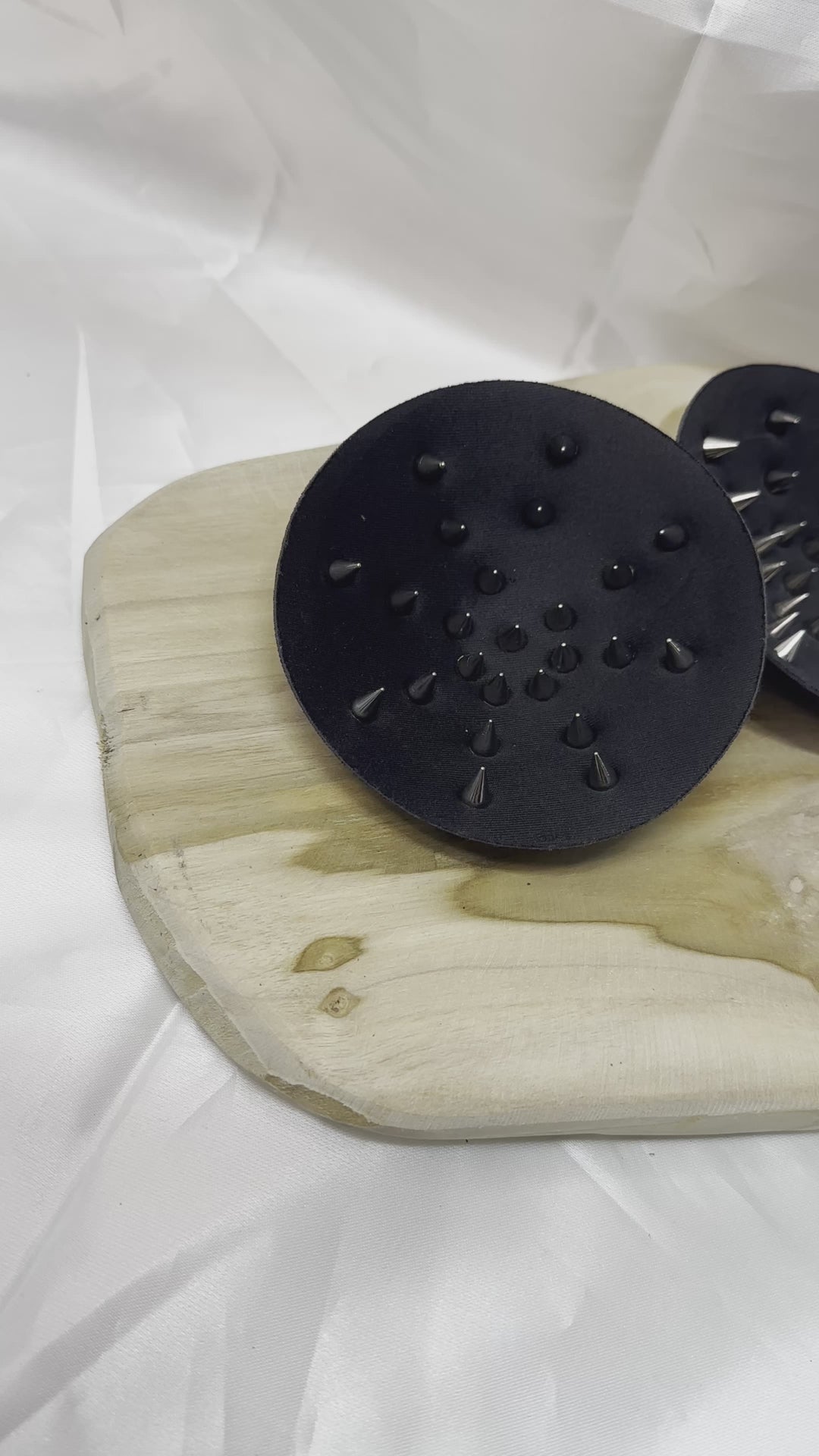 Pair of spiked bra inserts made from fabric with metal spikes for BDSM and sensory play.